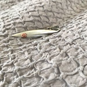 Vintage silver toned tie clip with a small flower.